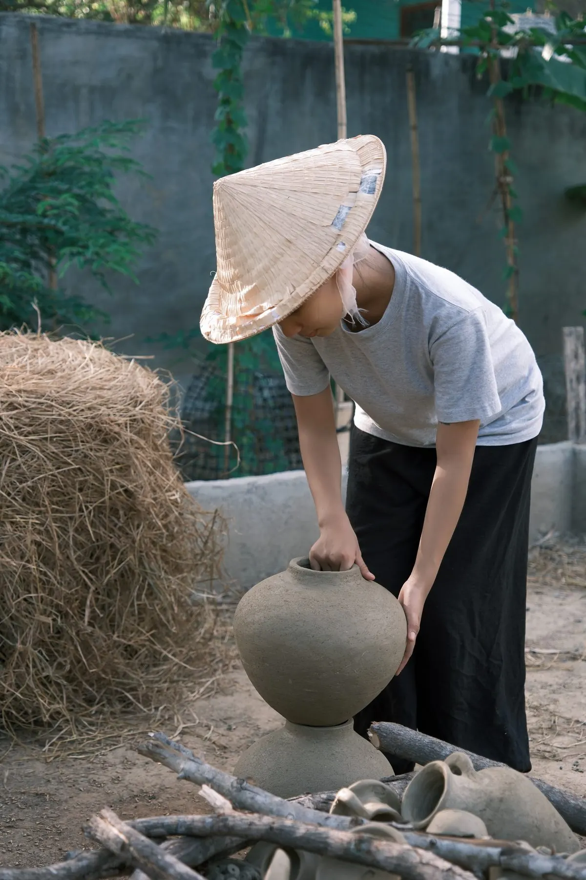 Bưng gốm đi ngang đống rơm