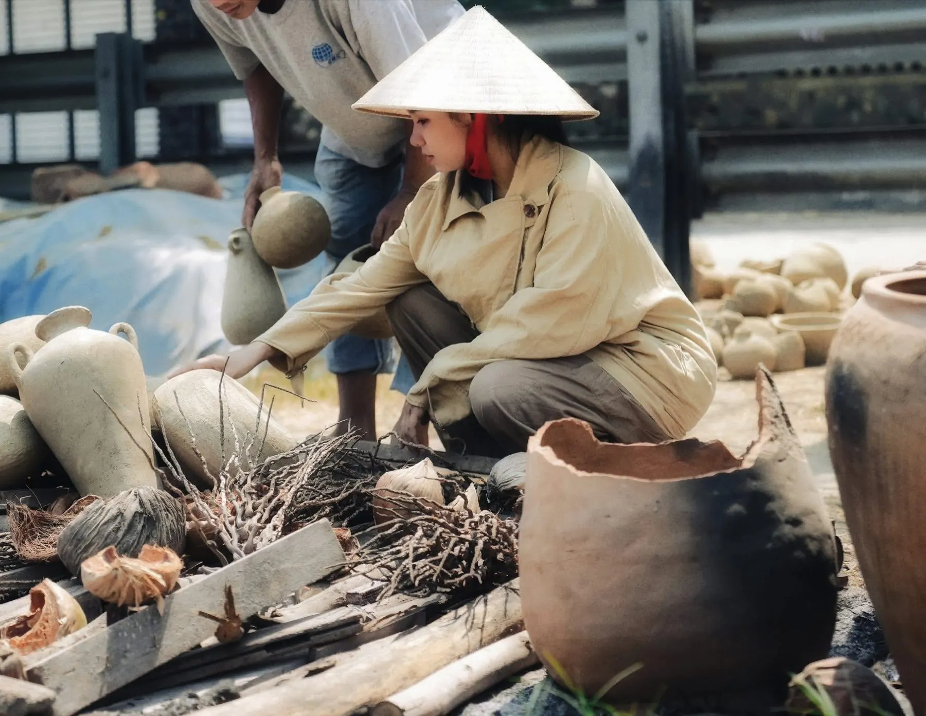 Người thợ đội nón lá chuẩn bị gốm để nung